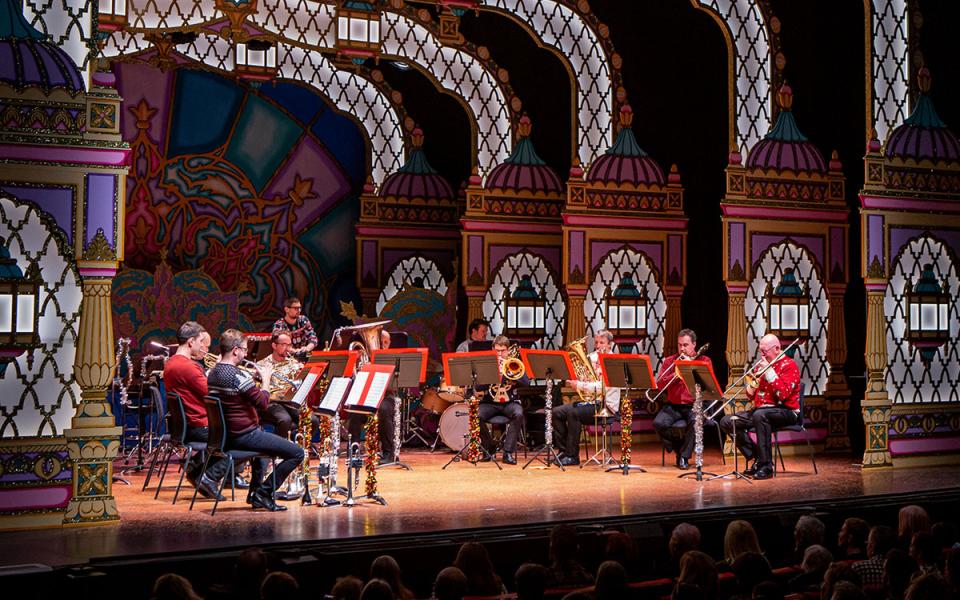 Philharmonia brass ensemble on stage at the Marlowe Theatre, against a colourful pantomime setting