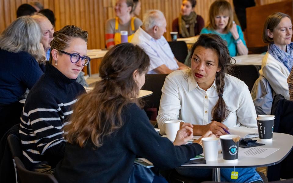 Three women in discussion sitting at a table